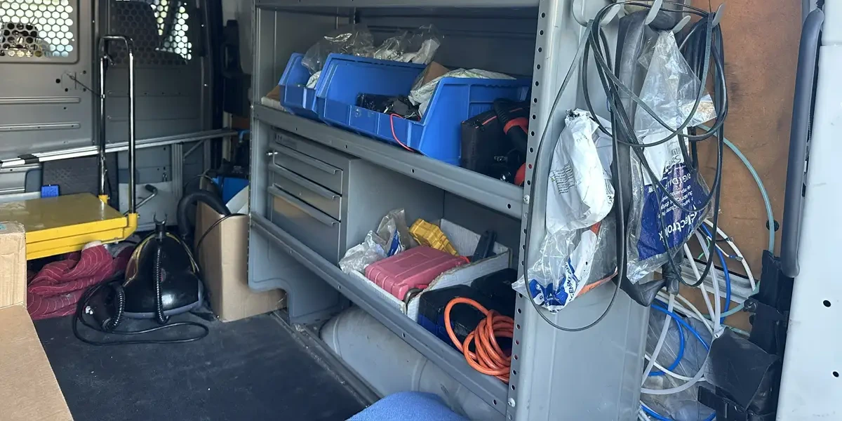 Parts bins, replacement belts and tools on the shelves inside Brian's service van